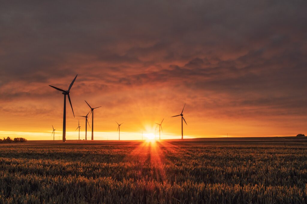 Wind turbines silhouetted against a sunset